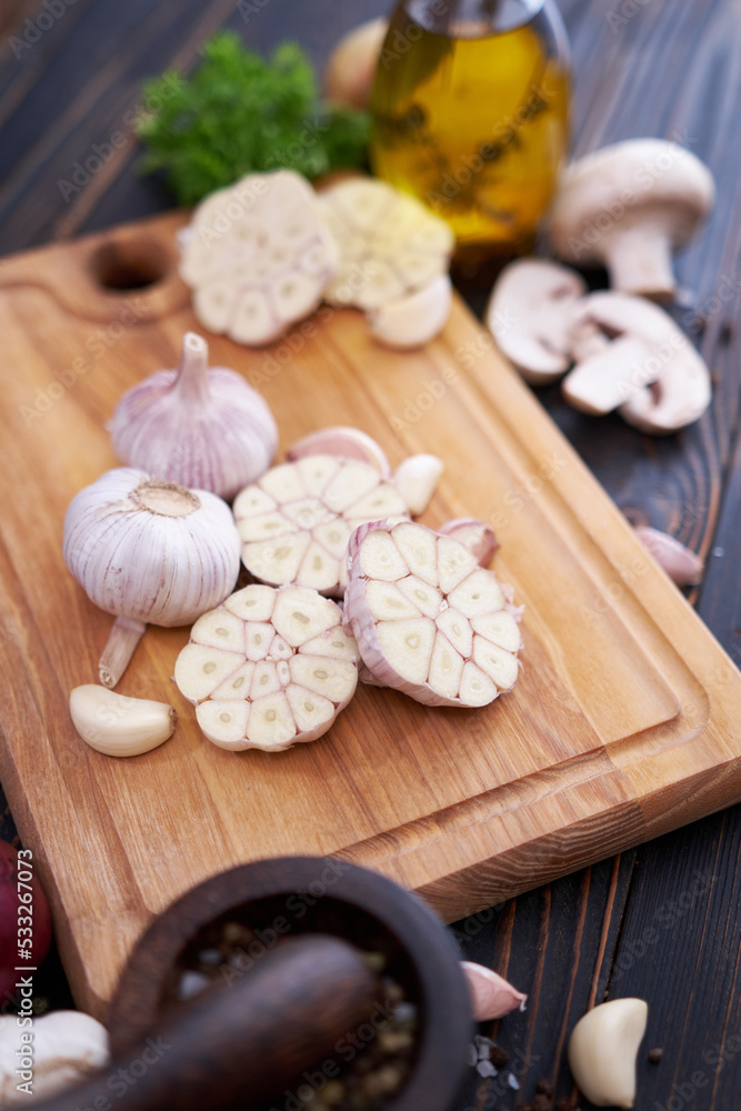 Garlic on wooden chopping board on wooden background or table