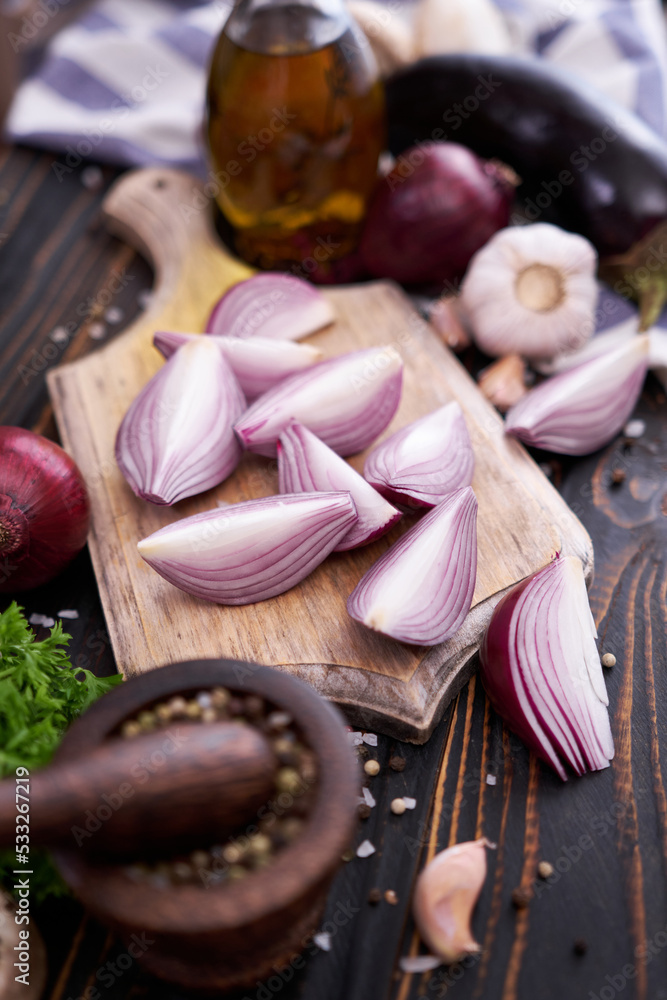 Red Onion on wooden cutting board with dark background