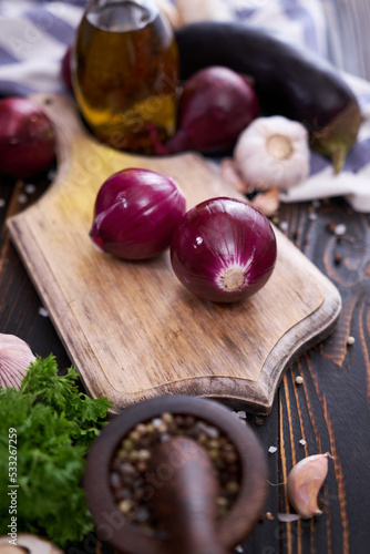 Red Onion on wooden cutting board with dark background