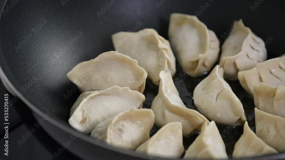 Pan-frying gyoza dumpling jiaozi at home. Pan-frying gyoza dumpling jiaozi at home.