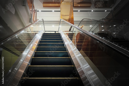 Perspective view of empty escalator in shopping center show nobody because of economics problems with dark edges all alround for business recession presentation background.