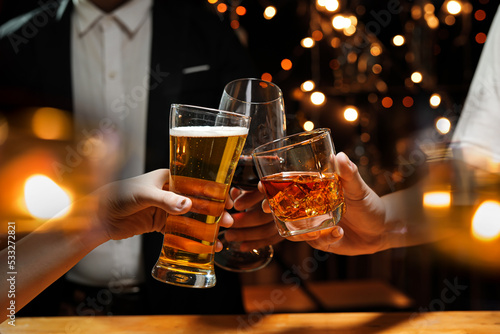 food and drink male friends are happy drinking beer and clinking glasses at a bar or pub.