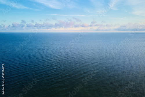 Drone flight over calm sea landscape with cloudy sky, Baltic sea panorama, aerial view