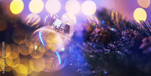 Closeup of glass Christmas ball on abstract light background.