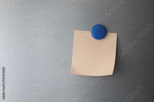 Blank paper on fridge door with blue magnet