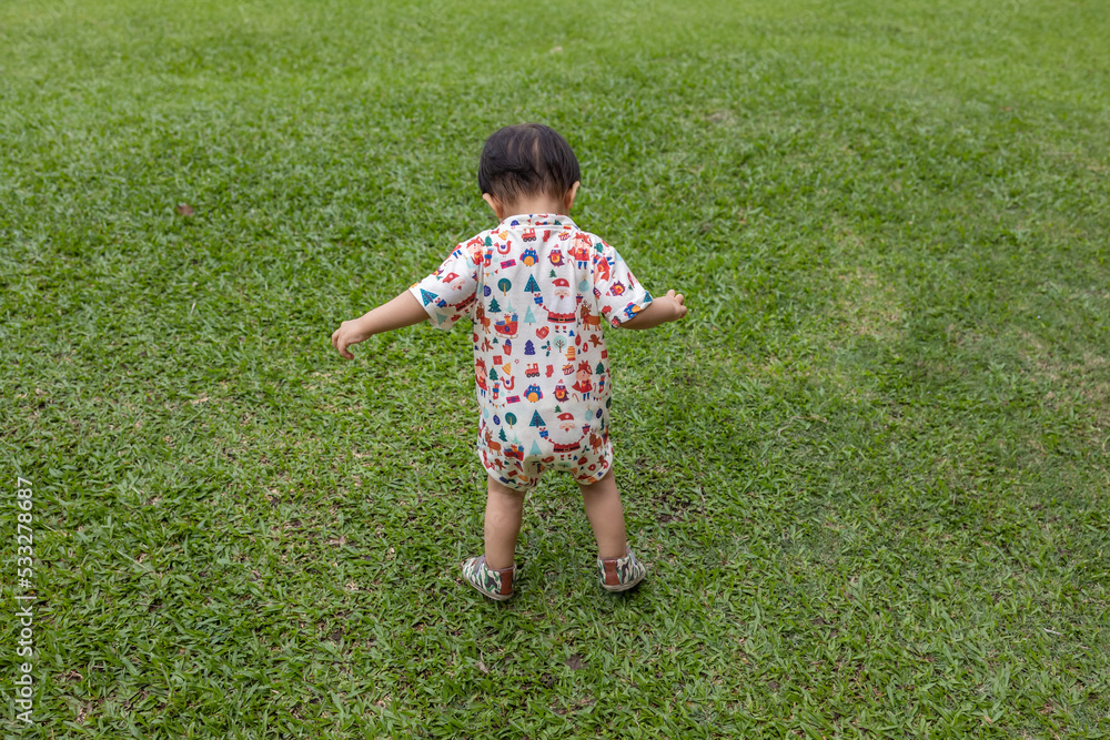 Portrait image of Happy 1-2 years old Asian Chinese child enjoying playing on clean green park Portrait image of Happy 1-2 years old Asian Chinese child enjoying playing on clean green park