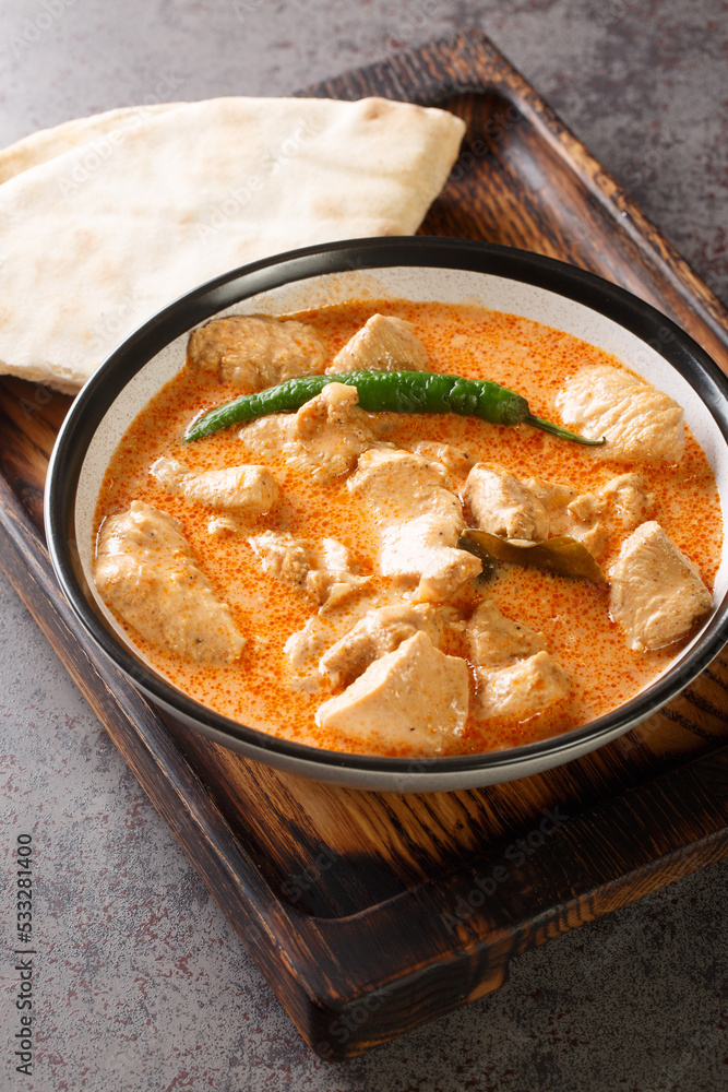 Sri Lankan Chicken Curry Kukul Mas with coconut milk and aromatic spices closeup in the bowl on the table. Vertical Sri Lankan Chicken Curry Kukul Mas with coconut milk and aromatic spices closeup in the bowl on the table. Vertical
