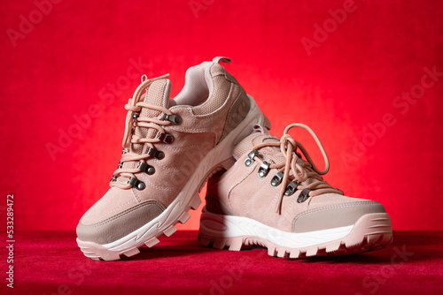 pink color hiking boots for lady on red © Freer