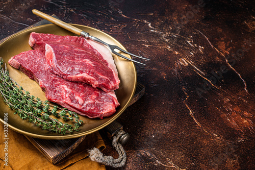 Freah Raw cap rump beef meat steak in a plate with thyme, top sirloin steak. Dark background. Top view. Copy space