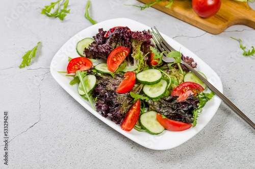 salad with fresh salad leaves, arugula, cherry tomato, cucomber photo