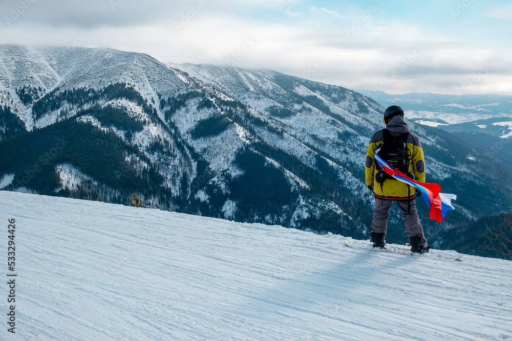 man snowboarder with slovakia flag at ski resort slope