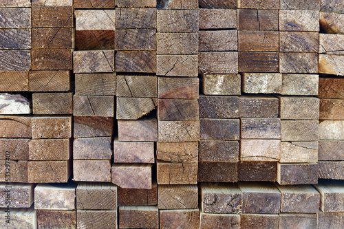 Blocks of pine sawn timber for the construction of roof houses and cottages stacked on the lumberyards site  ready for sale