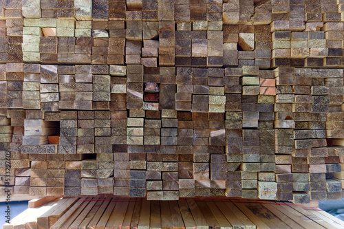 Blocks of pine sawn timber for the construction of roof houses and cottages stacked on the lumberyards site, ready for sale