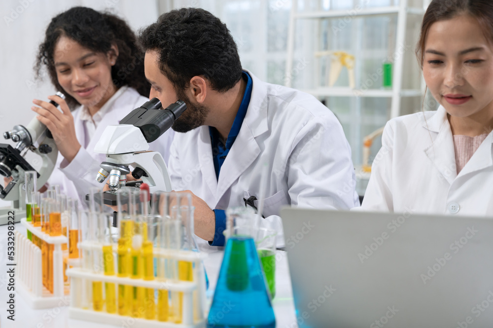 Scientist team in white laboratory coat working with microscope and laptop for research in scientific research laboratory . Scientist team in white laboratory coat working with microscope and laptop for research in scientific research laboratory .