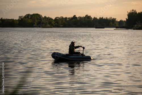 The young angler flows on the pontoon on the lake