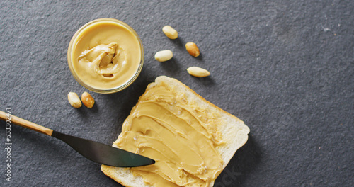 Image of close up of toast with peanut butter on gray background