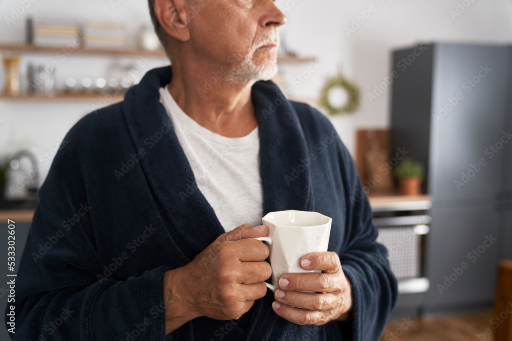 Close up of senior man holding cup of coffee at home Close up of senior man holding cup of coffee at home