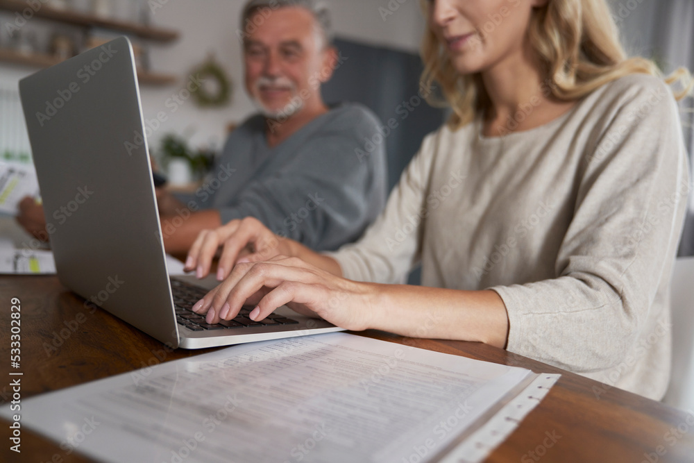 Close up of caucasian woman with senior dad paying bills online Close up of caucasian woman with senior dad paying bills online