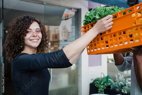 Happy young entrepreneur taking delivery of vegetables for restaurant photo