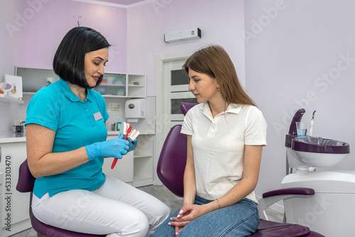 Dentist and patient choose treatment during consultation in beautiful clinic.