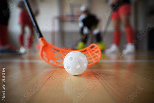 Obraz na plátně Close-up of floorball stick and ball during woman floorball match in gym