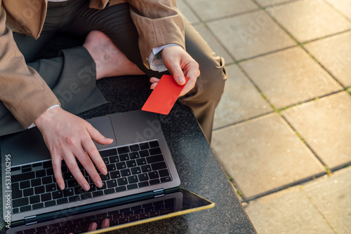 Businesswoman paying online through credit card using laptop photo