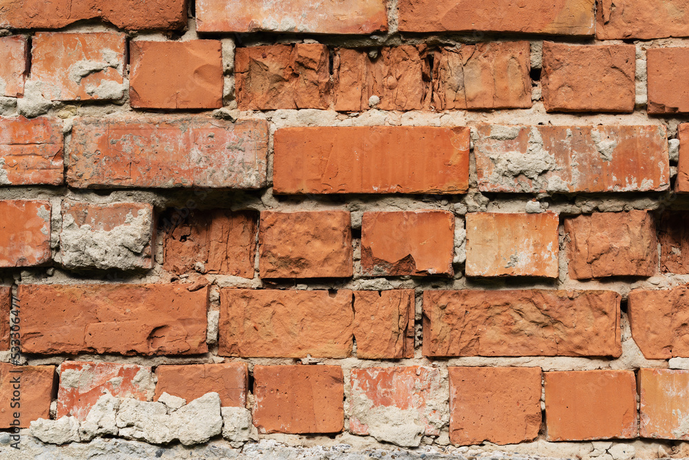 Obraz premium Old weathered brick non-plastered wall surface close-up