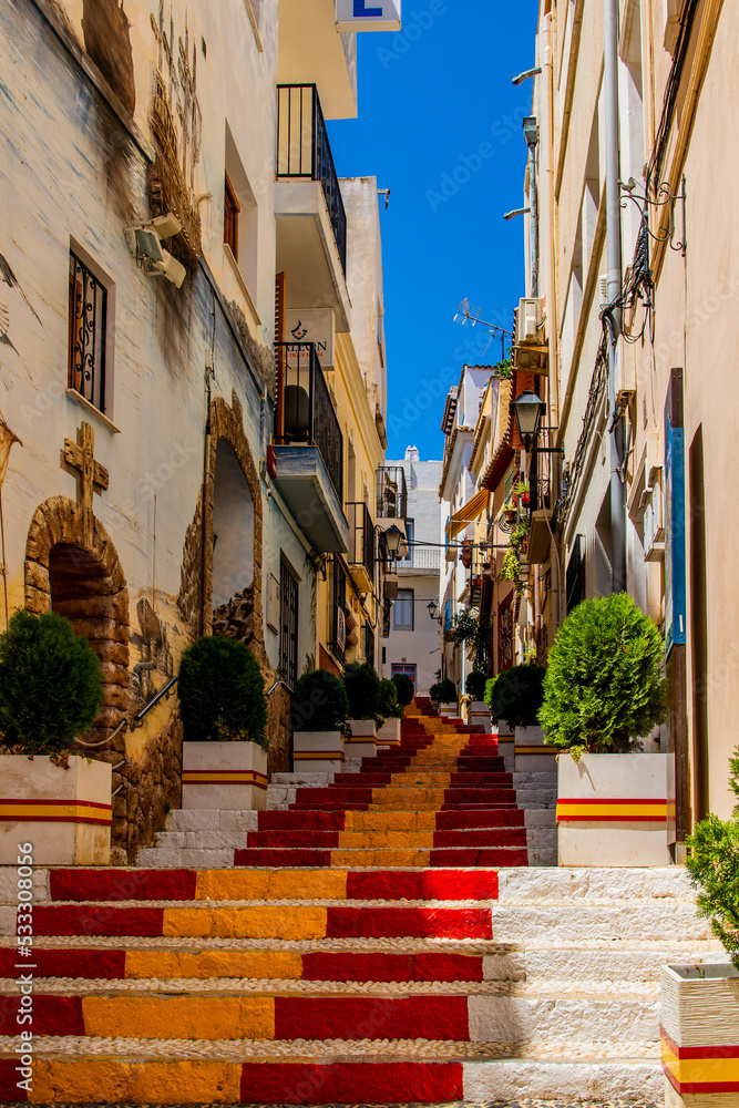  antique staircase in Calpe, Spain in the old town painted red and yellow in the color of the country's flag