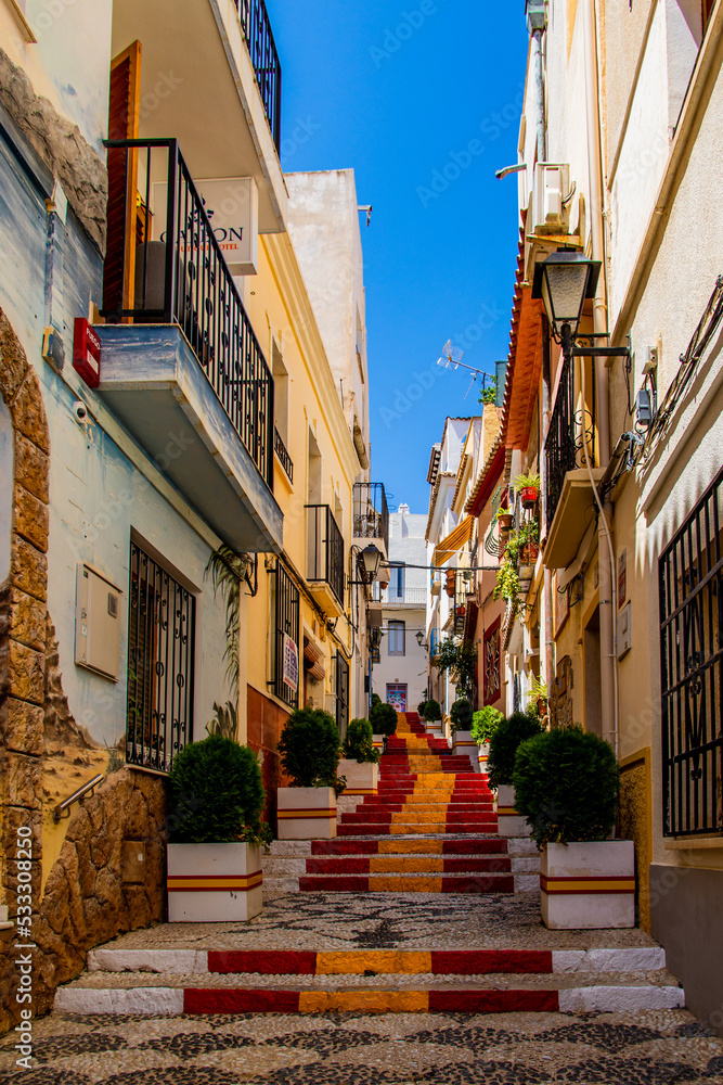  antique staircase in Calpe, Spain in the old town painted red and yellow in the color of the country's flag