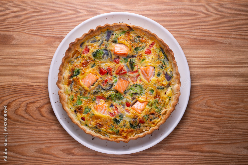 Salmon and vegetable quiche. Traditional French recipe with fish and fresh vegetables with handmade dough and egg. Salmon and vegetable quiche. Traditional French recipe with fish and fresh vegetables with handmade dough and egg.