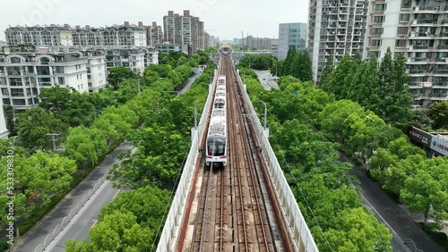 The metro station outdoor and the train in the city. Drone aerial view. The subway track and station in the city. Aerial view of the train .  Transportation cityscape business concept b-roll footage.