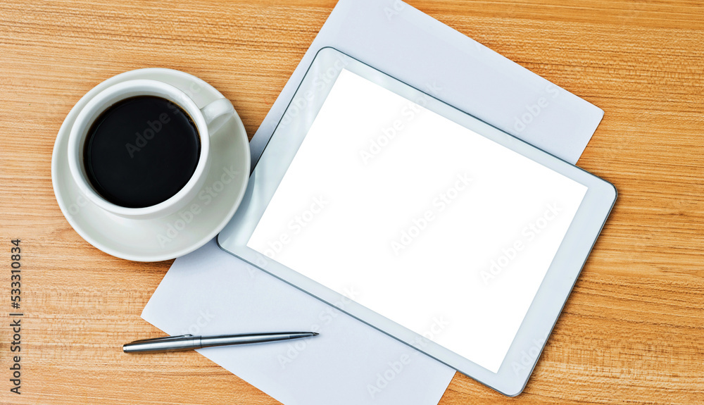 Digital tablet and a cup of coffee on the desk Digital tablet and a cup of coffee on the desk