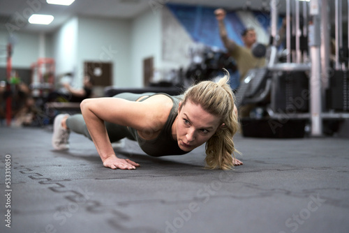 Young caucasian woman make hard training at the gym