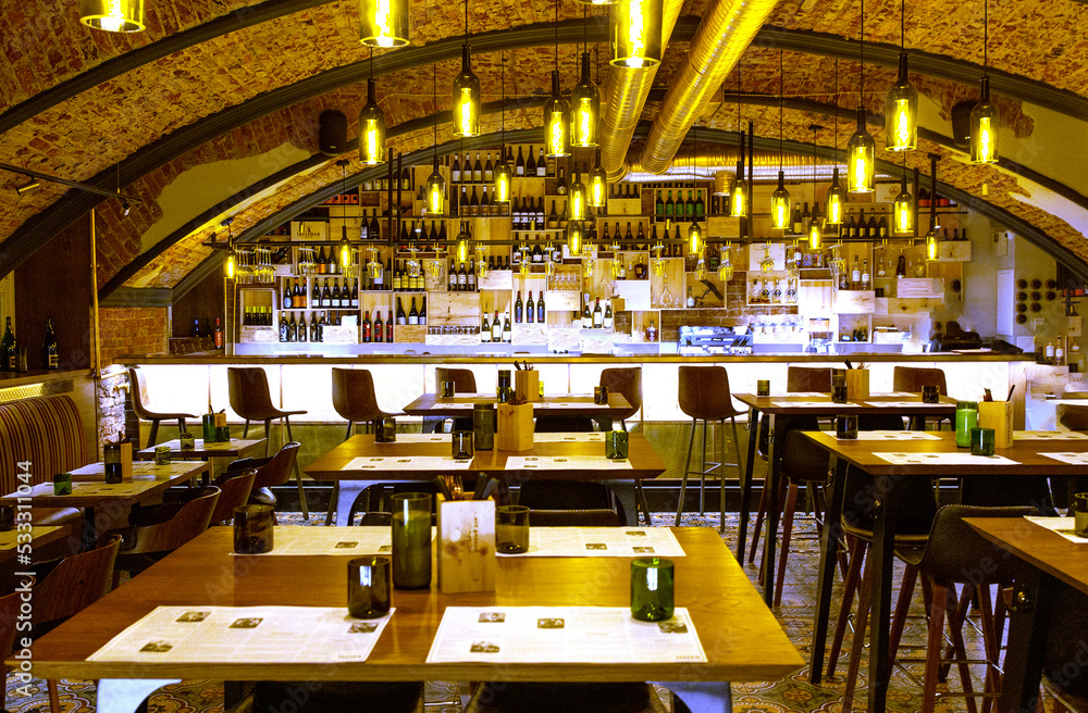 Fototapeta premium Interior of cozy modern restaurant with a bar counter and lamp lighting