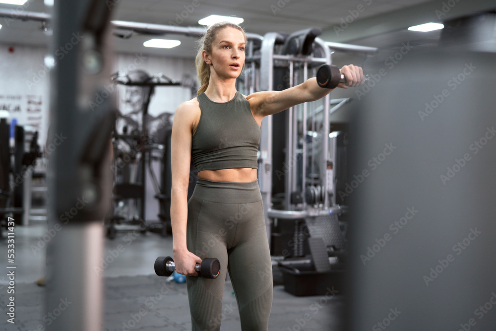 Adult caucasian woman training with weights at the gym