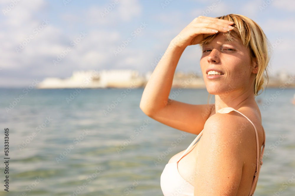 Beautiful woman swimming in the ocean. Smiling blonde girl enjoy in sunny day..