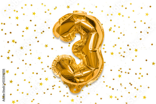 The number of the balloon made of golden foil, the number three on a white background with sequins. Birthday greeting card with inscription 3. Numerical digit, Celebration event.