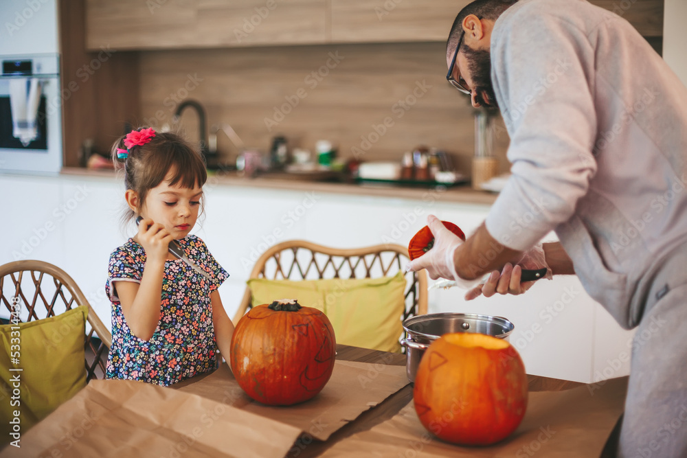 Fototapeta premium Family carving pumpkins together for Halloween