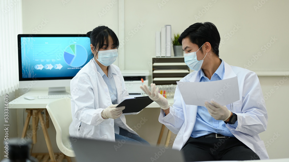 Young researcher scientist analyzing test samples, discussing about new test results in laboratory Young researcher scientist analyzing test samples, discussing about new test results in laboratory