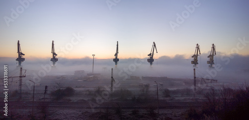Port cranes shrouded in the morning mist.