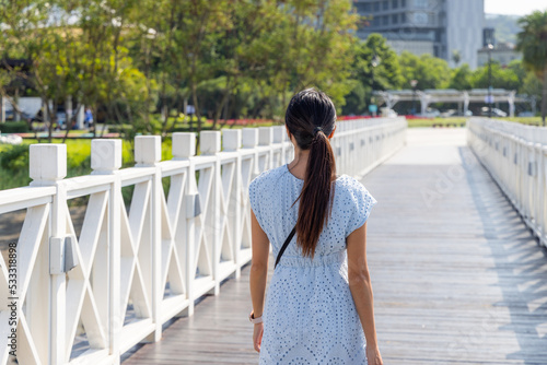 Travel woman walk on the white wooden bridge © leungchopan