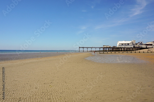 Typical English beach with old Victorian pier structure. View across empty beach at low tide in Bognor Regis, West Sussex UK photo