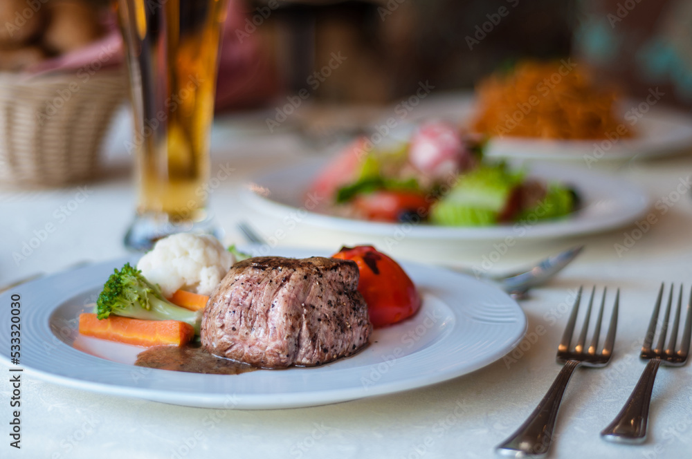 An International cuisine. A beef stake with vegetable served in a plate. A fine dining restaurant. An International cuisine. A beef stake with vegetable served in a plate. A fine dining restaurant.