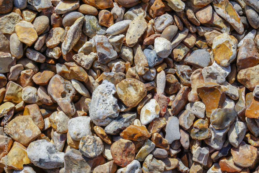 pebble stone background. various shape and color stones on shingle beach. pebble stone background. various shape and color stones on shingle beach.