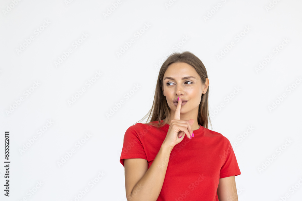 Young woman holding finger on lips mouth to keep it quiet hush standing isolated on white background with copy space Young woman holding finger on lips mouth to keep it quiet hush standing isolated on white background with copy space