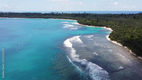 Drone aerial crystal clear blue landscape scenic shot of tropical holiday destination rocky reef sandy beach palm trees travel tourism Indonesia Mentawai Islands Asia 4K photo
