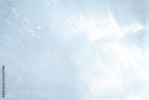 Blurred ripple water texture on white background. Shadow of water on sunlight. Mockup for product, spa or travel background. Marble water surface as wallpaper background