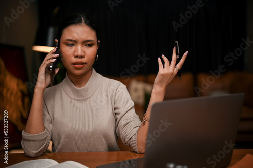 Canvas Print A female boss is complaining about her employee's work through the phone in the evening