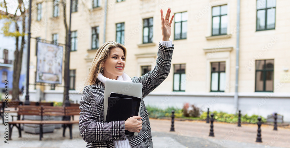young businesswoman raises her hand and waves while meeting her colleague, concept of a strong successful woman