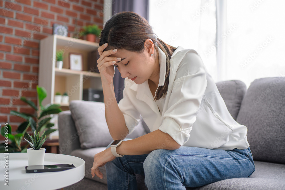 Unhappy young asian woman sit on sofa at home stressed depressed about life relationships problems. Unhappy young asian woman sit on sofa at home stressed depressed about life relationships problems.